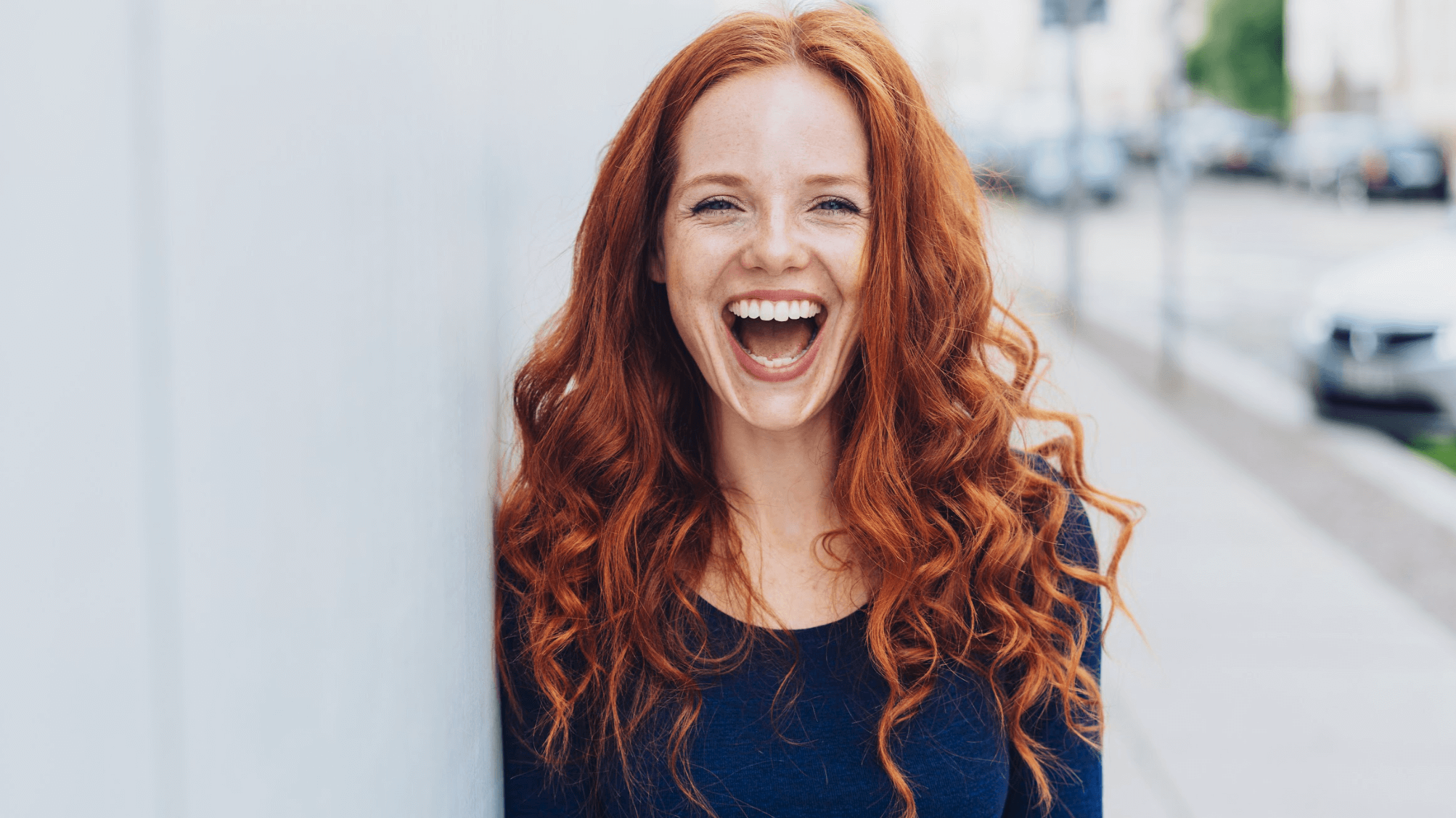 red-haired woman smiling outsi